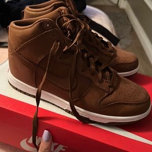 Woman’s brown Nike high dunks